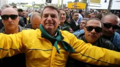 Bolsonaro sorrindo com vestimentas em verde e amarelo rodeado por seguranças e apoiadores nas ruas