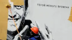 Коммунальный работник закрашивает граффити с Навальным в Санкт-Петербурге