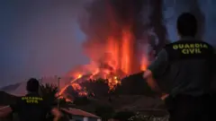 Miembros de la Guardia Civil en las Islas Canarias observan la erupción del volcán Cumbre Vieja.