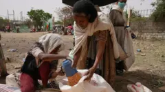 Umukozi utanga imfashanyo aha imfashanyo umugore mu gace ka Geha muri Ethiopia