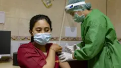 Una mujer recibe una vacuna en Indonesia