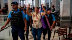 Policías nicaragüenses detienen a una mujer que participaba en un plantón en un centro comercial
