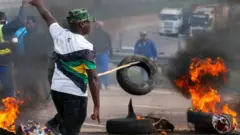 Abashyigikiye uwahoze ari Perezida w'Afurika y'epfo Jacob Zuma bafunze umuhanda bakoresheje imipine yaka, mu myigaragambyo i Peacevale muri Afurika y'epfo, ku itariki ya 9 y'ukwa karindwi mu 2021.