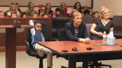Un niño, un hombre y una mujer en un tribunal