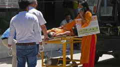 দিল্লির একটি হাসপাতালে স্ট্রেচারে করে রোগীকে নিয়ে আসছেন তাদের আত্মীয়রা