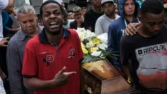 Amigos participam de cortejo de jovem morto pela PM em 2015
