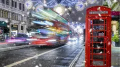 A bus travelling under the Christmas lights in London's West End