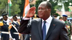 Alassane Ouattara exécutant le salut militaire lors de la fête de l'indépendance.