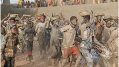 عمال ومواطنون ماليون يجصصون المسجد الكبير في جينية