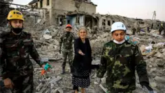 Rescuers and civilians amid debris in Ganja