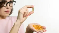 Mujer con una cápsula en la mano