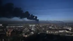 Black smoke rises from a military airport in Chuguyev near Kharkiv on February 24, 2022