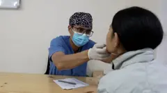 मुखको जाँच गर्दै।