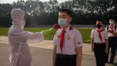 북한 평양의 한 학교 학생이 발열 체크를 받는 모습