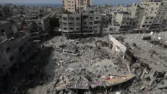 Palestinians search for bodies and survivors among the rubble of a destroyed building following Israeli airstrikes on northern Gaza, 28 October 2023.