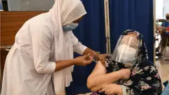 বঙ্গবন্ধু শেখ মুজিব মেডিকেল ইউনিভার্সিটি হাসপাতালে দ্বিতীয় ডোজ টিকা নিচ্ছেন একজন নারী- ২৬শে এপ্রিল ২০২১