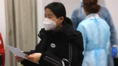 意大利米蘭馬爾彭薩機場一名中國女旅客排隊接受入境新冠核酸檢測（29/12/2022）