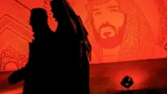 سعودي يسير بجانب صورة ولي العهد