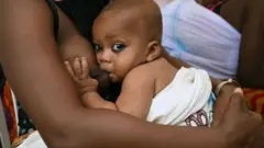 Woman dey breast feed pikin