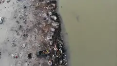 In this aerial photograph taken on May 5, 2021 funeral pyres of Covid-19 coronavirus victims are seen in a cremation ground along the banks of the Ganges River, in Garhmukteshwar