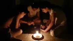 เด็ก ๆ นั่งล้อมวงจุดเทียนไข