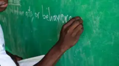 ሓደ መምህር ኣብ ሰሌዳ እናጸሓፈ