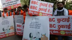 Activists from the Hindu Sena group protest with placards reading "BBC quit India" and "BBC beating day" outside the BBC office in Delhi, 15 February