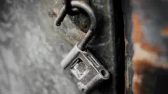 Открытый замок на металлической двери
