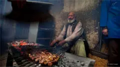 Un cuisinier fait griller des brochettes dans un restaurant de marché à Kaboul.