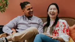 A man and woman laughing together.