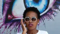 A woman looks on outside an optometrist clinic in Randfontein, west of Johannesburg, South Africa, February 14, 2022.