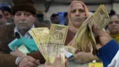 An Indian bank teller counts old notes