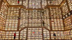 विशाल पुस्तकपसलमा उभिएर पुस्तक पढ्दै गरेका मानिसहरू