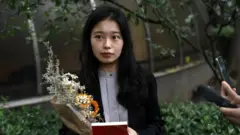 Zhou Xiaoxuan, also known by her online name Xianzi, speaks to supporters as she arrives at a court for a sexual harassment case involving a Chinese state TV host, in Beijing, China on 14 September 2021