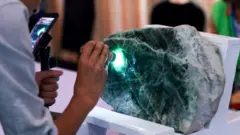 Jade vendor inspects large chunk of Jade in Myanmar
