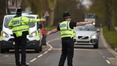 Police officers from North Yorkshire Police stop motorists in cars to check that their travel is "essential", in line with the British Government"s Covid-19 advice to "Stay at Home", in York, northern England