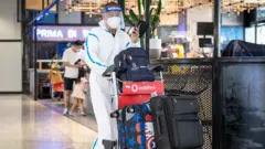 مسافر يرتدي عدة الوقاية من فيروس كورونا