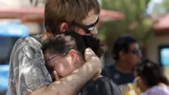 Kianna Long (R) is comforted by a relative