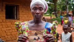 Suriya Muyombe holds a picture of her missing child