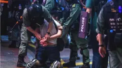 Hong Kong police detain a man in Causeway Bay, 12 June