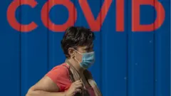 Una mujer con mascarilla.