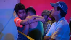 A man is comforted at a crime scene following a deadly attack at a bar by unknown assailants in Coatzacoalcos, Mexico August 28, 2019.