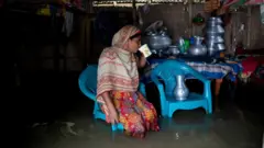পানি বাড়ার পরও নিজের ভিটামাটি ছাড়তে চাইছেন না অনেকেই।