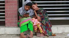দুটি মেয়ে মোবাইল ফোন দেখছে।