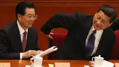 هو جين تاو (يسار) وشي جينبينغ في المؤتمر الشعبي الوطني مارس/آذار من عام 2013
