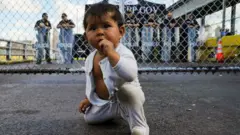 এক বছর বয়সী মেক্সিকান শিশু অপেক্ষা করছে মায়ের সাথে যুক্তরাষ্ট্রে আশ্রয়প্রার্থী হিসেবে প্রবেশ করার জন্য