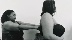 A plus-size woman helps another to dress