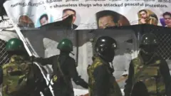 Members of Sri Lankan security forces remove temporary structures set up by anti-government protesters