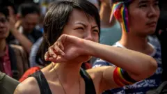 A woman weeps with joy in Taipei after Taiwan's parliament votes to legalise same-sex marriage, 17 May 2019