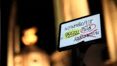 ผู้ชุมนุมชูไอแพดที่เขียนข้อความแสดงความเห็น
